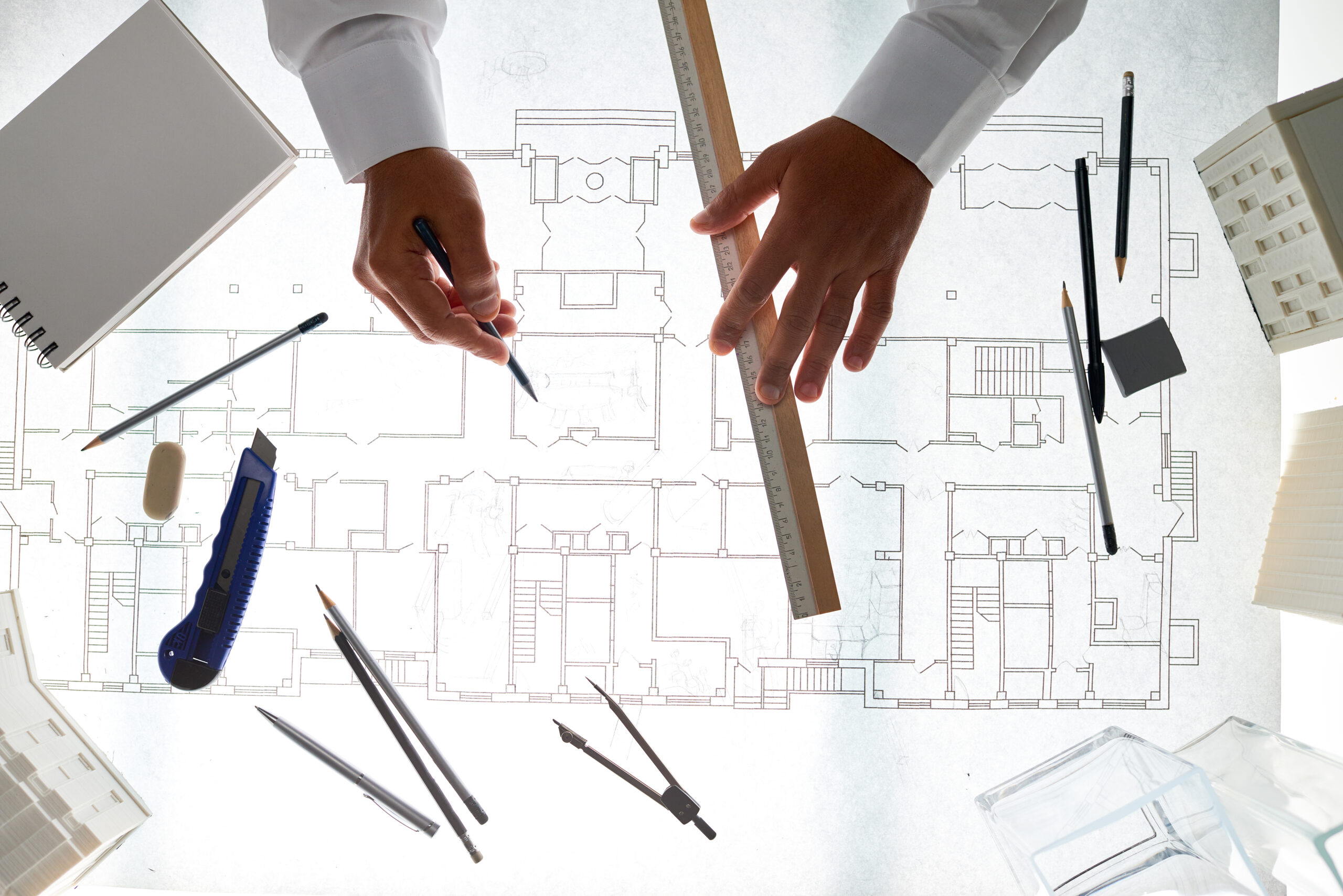 Top view background of architect hands drawing blueprints at workstation in office, copy space